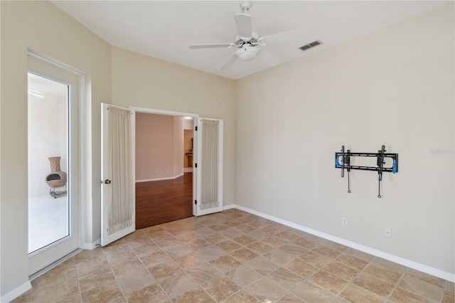 spare room featuring baseboards, visible vents, and ceiling fan