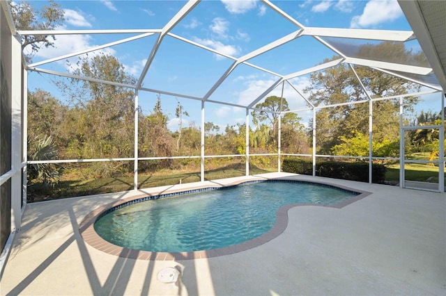 pool featuring glass enclosure and a patio area