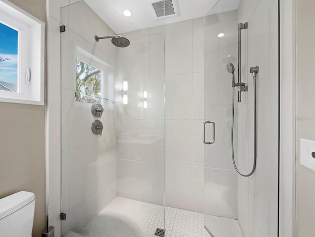 bathroom with a stall shower, visible vents, and toilet