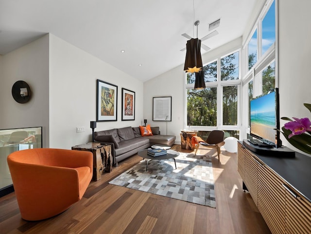 living area featuring high vaulted ceiling, wood finished floors, and visible vents