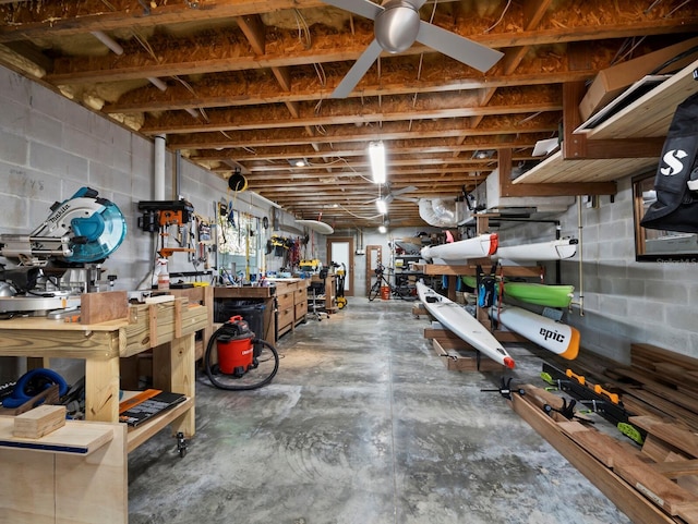 basement with concrete block wall, ceiling fan, and a workshop area