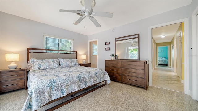 bedroom with ceiling fan, light carpet, light tile patterned floors, and multiple windows