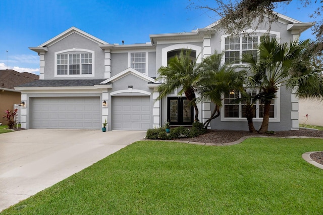 view of front of house featuring a garage, driveway, a front lawn, and stucco siding