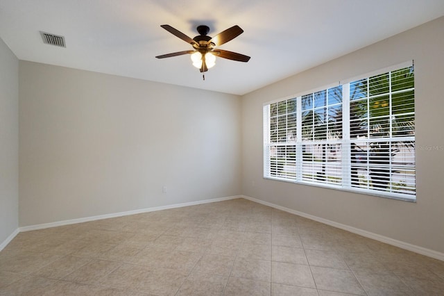 unfurnished room with a ceiling fan, visible vents, baseboards, and light tile patterned floors