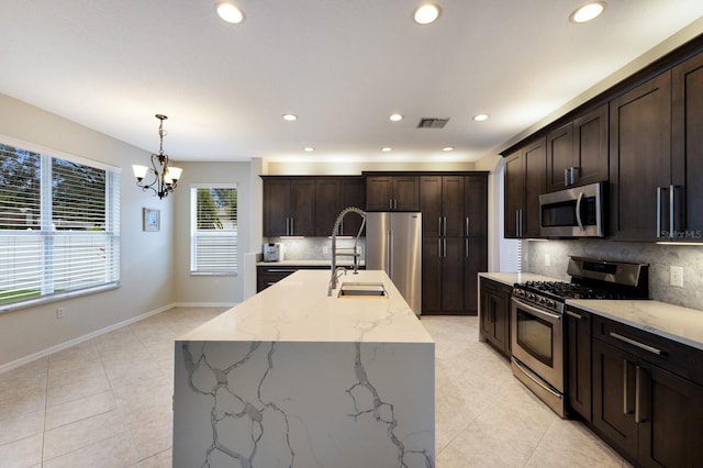 kitchen with dark brown cabinetry, visible vents, appliances with stainless steel finishes, light stone countertops, and pendant lighting