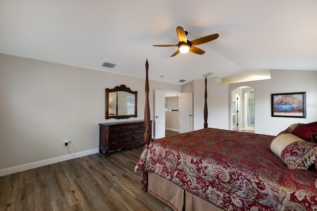 bedroom featuring baseboards, visible vents, arched walkways, lofted ceiling, and wood finished floors