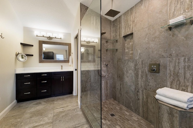 full bath featuring vanity, baseboards, and a walk in shower