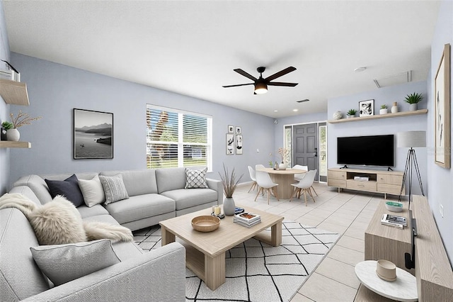 living area with light tile patterned floors and ceiling fan