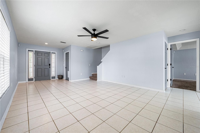 unfurnished living room featuring a ceiling fan, stairway, baseboards, and light tile patterned floors