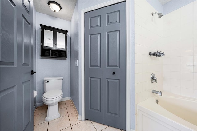 bathroom featuring bathing tub / shower combination, a closet, toilet, a textured ceiling, and tile patterned floors