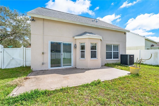 back of property featuring a yard, stucco siding, a patio area, central AC, and fence