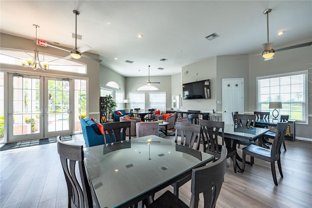 dining area with french doors, light wood finished floors, and visible vents