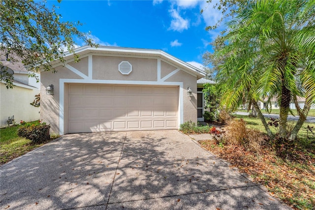 single story home with a garage, driveway, and stucco siding