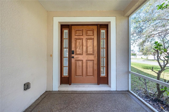 doorway to property featuring stucco siding