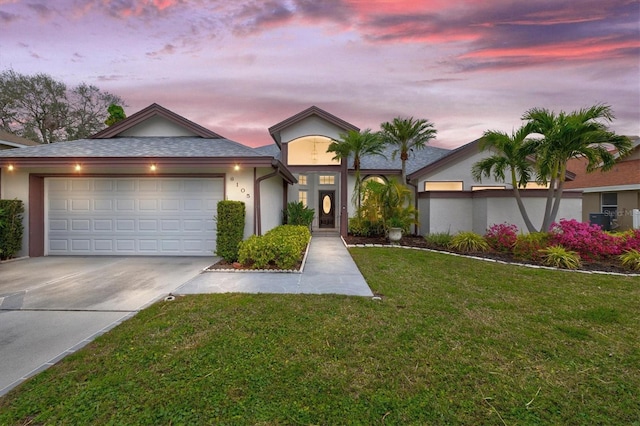 view of front of property with a front lawn, concrete driveway, an attached garage, and stucco siding