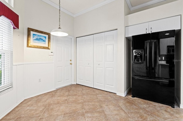 unfurnished dining area with light tile patterned floors, wainscoting, and crown molding