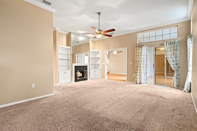 unfurnished living room with a textured ceiling, carpet floors, ornamental molding, and a fireplace with flush hearth