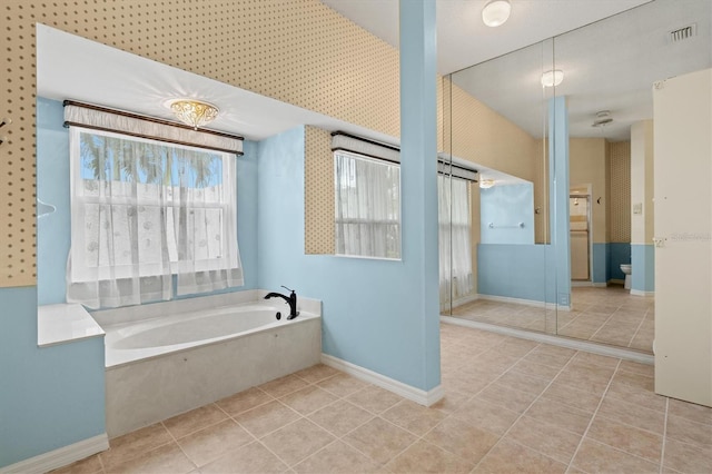 full bathroom with a garden tub, visible vents, toilet, baseboards, and tile patterned floors