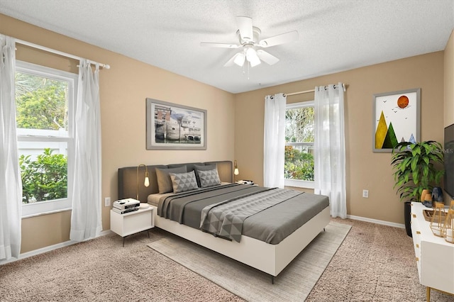 bedroom with carpet floors, ceiling fan, a textured ceiling, and baseboards