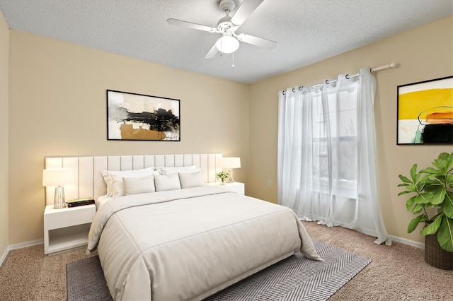 bedroom featuring light carpet, a textured ceiling, and baseboards