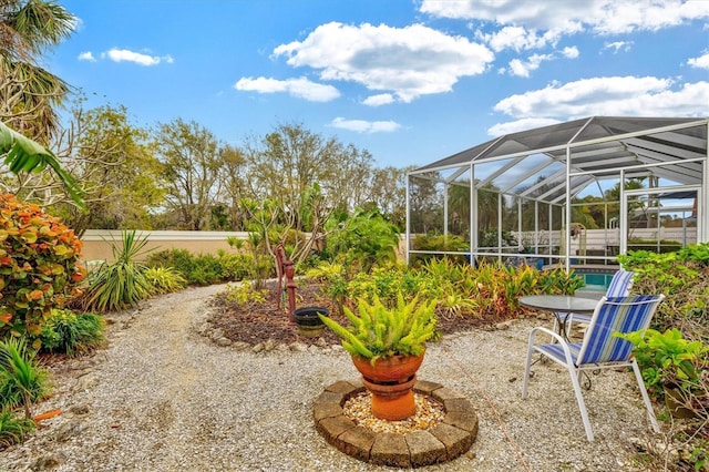 view of yard featuring glass enclosure and fence