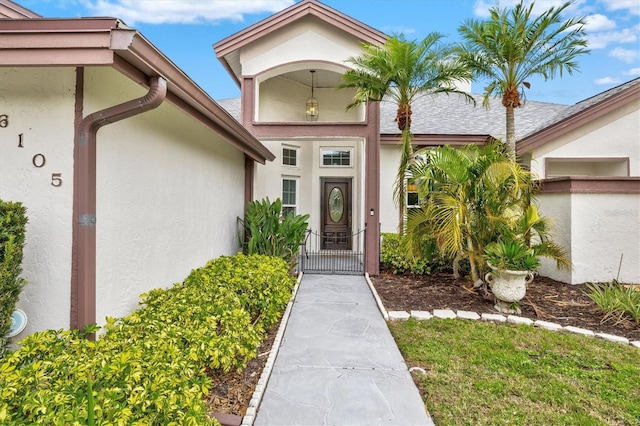 doorway to property with a gate and stucco siding