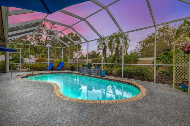 pool at dusk with a patio, a lanai, and an outdoor pool