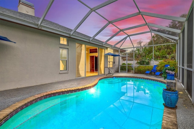 pool with glass enclosure and a patio area