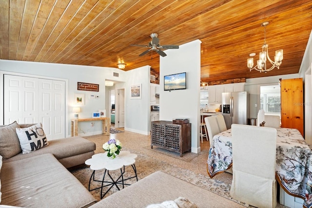 living area with lofted ceiling, wood ceiling, baseboards, and ceiling fan with notable chandelier