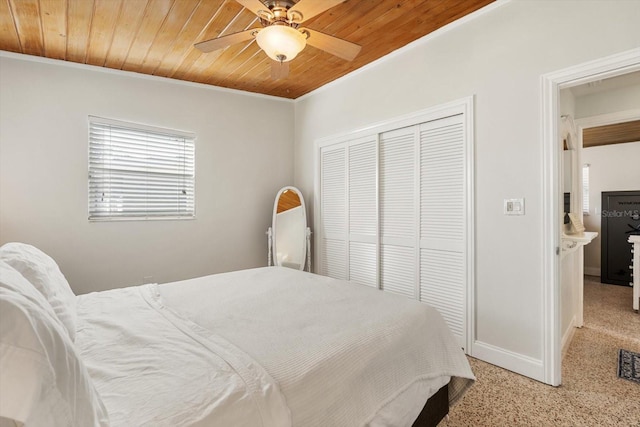 bedroom with crown molding, a closet, ceiling fan, wooden ceiling, and baseboards