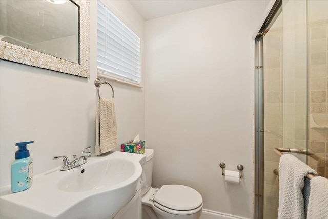 full bathroom with a stall shower, baseboards, a sink, and toilet