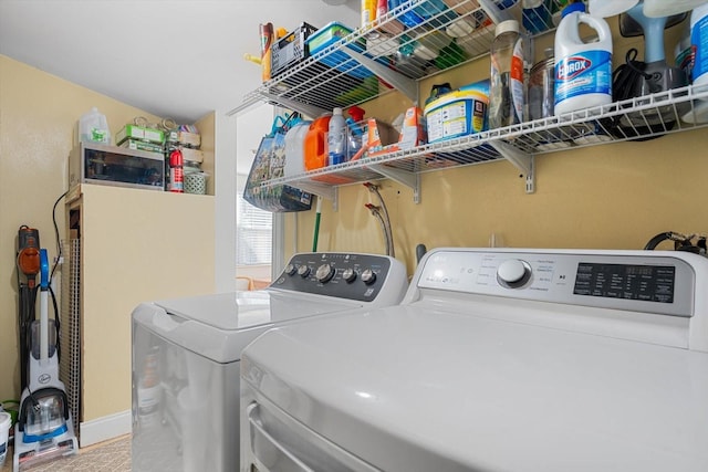 laundry room featuring laundry area, washing machine and clothes dryer, and baseboards