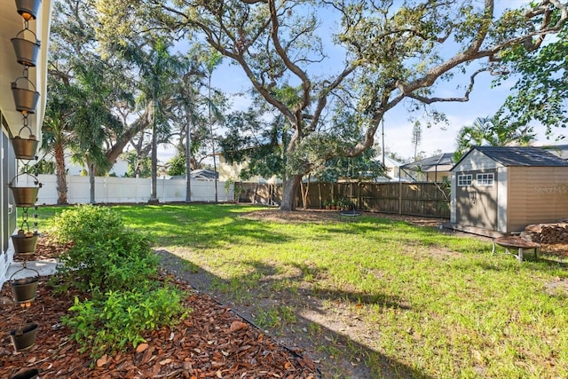 view of yard featuring an outbuilding, a fenced backyard, and a shed