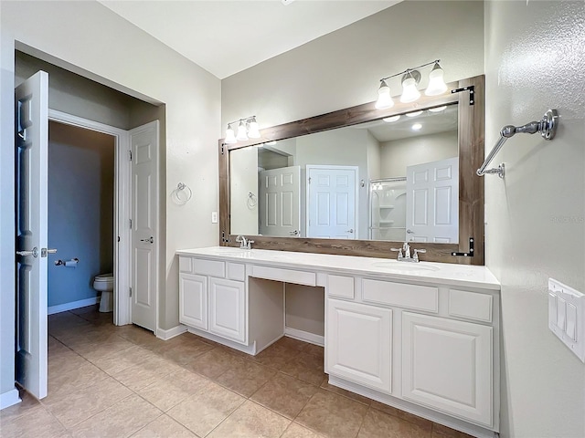 full bathroom with double vanity, a sink, toilet, and tile patterned floors