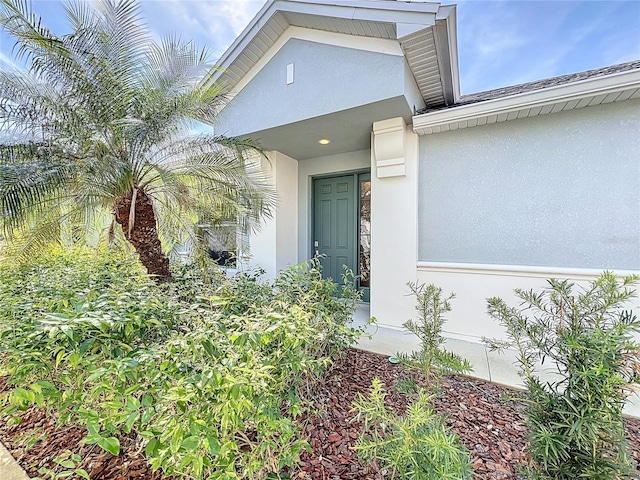 doorway to property featuring stucco siding