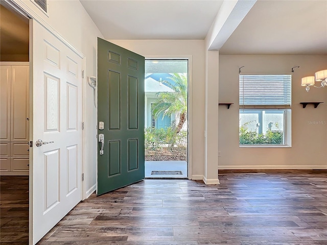 entrance foyer featuring a healthy amount of sunlight, baseboards, and dark wood finished floors