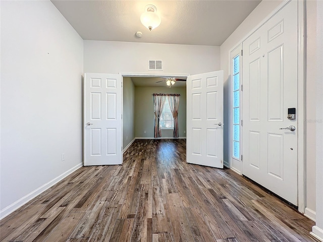 foyer with dark wood-style floors, visible vents, and baseboards