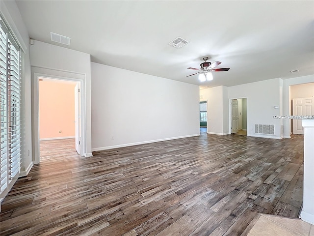 unfurnished living room with visible vents, dark wood finished floors, and ceiling fan