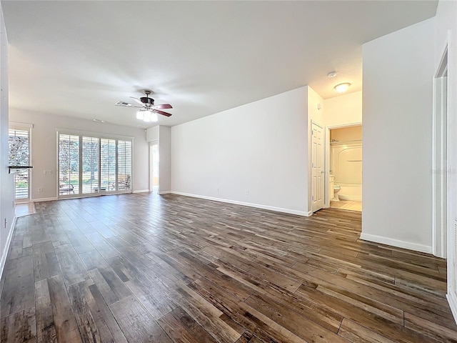 unfurnished living room featuring dark wood-type flooring, visible vents, ceiling fan, and baseboards