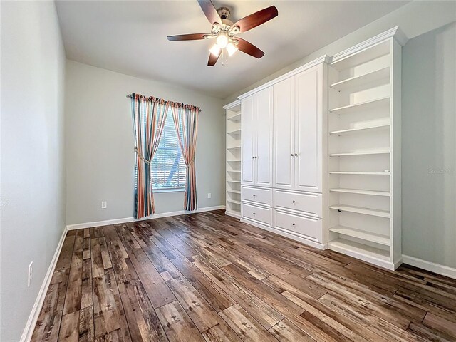 unfurnished bedroom featuring a closet, wood-type flooring, a ceiling fan, and baseboards