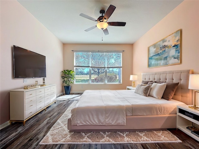 bedroom featuring dark wood-style floors, a ceiling fan, and baseboards