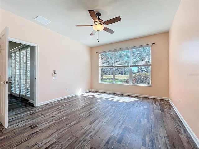 unfurnished room featuring ceiling fan, dark wood finished floors, visible vents, and baseboards