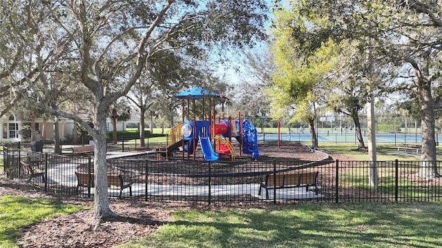 community play area featuring a yard and fence