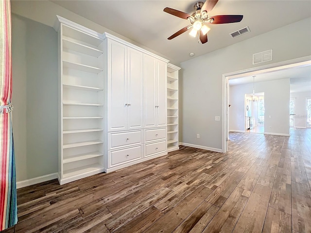 unfurnished bedroom with dark wood-style floors, baseboards, visible vents, and a closet