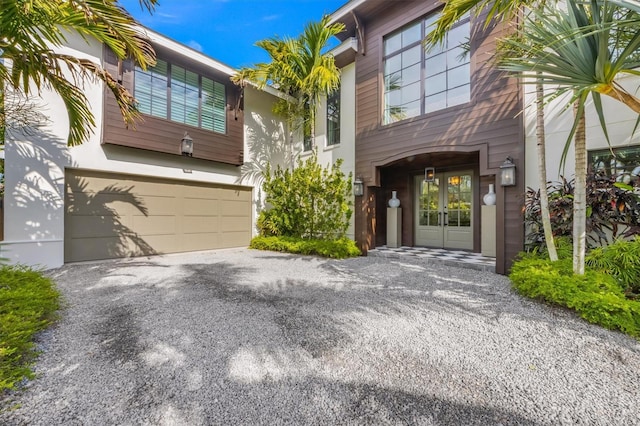 view of front of home featuring aphalt driveway, french doors, and an attached garage