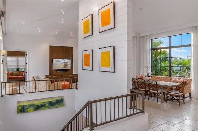 stairs featuring stone tile flooring and wood walls