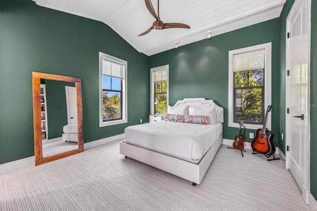 bedroom featuring vaulted ceiling, multiple windows, and baseboards