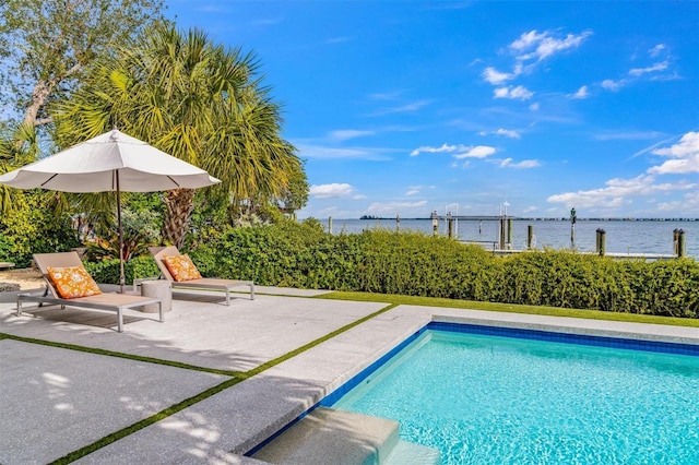 view of swimming pool with a fenced in pool, a water view, and a patio area