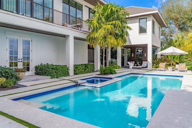 view of pool with a patio, french doors, and a pool with connected hot tub