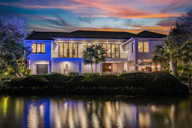 rear view of house featuring stucco siding and a water view